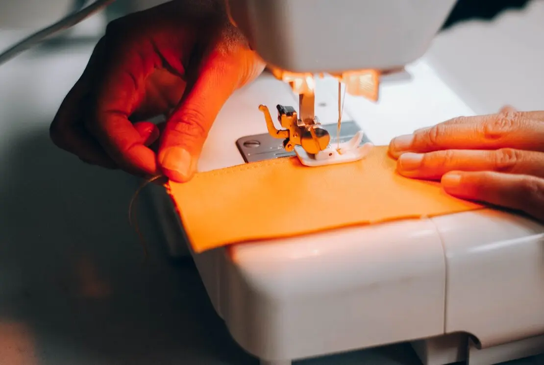 Dettaglio di mani che lavorano un tessuto di tappezzeria